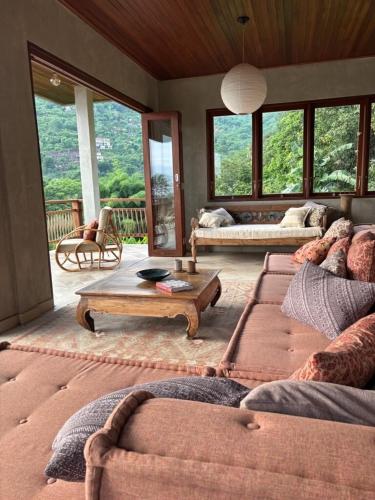 a living room with two couches and a table at First Light Villa at Lipah Beach, Amed in Amed