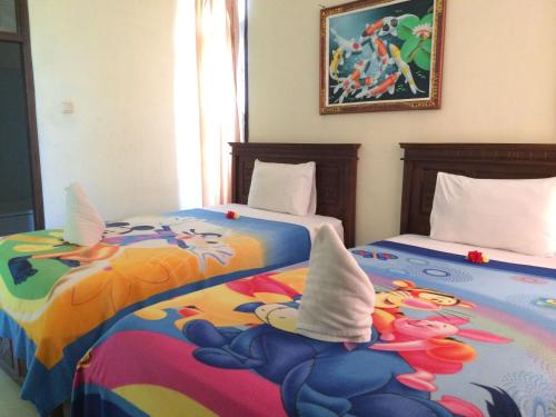 two beds sitting next to each other in a room at Lucky Paradise Bungalows on The Beach in Amed