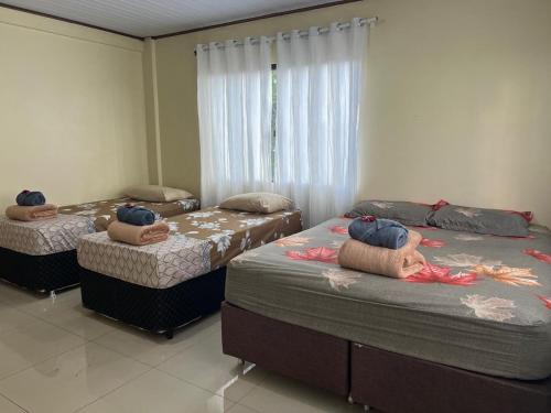 a room with three beds in a room at Pousada Taylor in Foz do Iguaçu