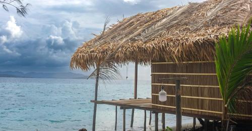 a hut on the beach with the water at Villa Homestay in Mesemta