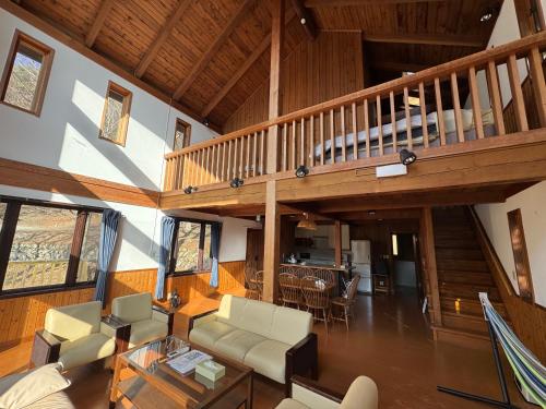 an open living room with a staircase and a living room at Cabin B vacation house rental Mt Fuji View 3 min lake Saiko 5min drive Lake Kawaguchi in Fujikawaguchiko