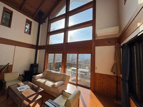a living room with a couch and a large window at Cabin B vacation house rental Mt Fuji View 3 min lake Saiko 5min drive Lake Kawaguchi in Fujikawaguchiko