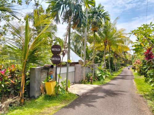 a street with palm trees on the side of a road at Nostalgia Camping Home 1 in Selemadeg