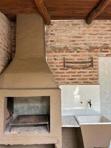 a kitchen with a brick oven with a sink at La Cabaña de Caro in Mar de Cobo