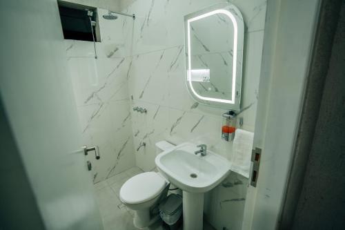 a bathroom with a sink and a toilet and a mirror at Hotel Urban Biz in Pilar