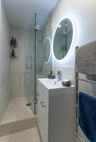 a bathroom with a sink and a glass shower at Stylish Lyttelton Studio Free Parking in  Lyttelton