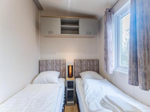 two beds in a small room with a window at Bright Beachside Base in Burgh-Haamstede in Burgh Haamstede