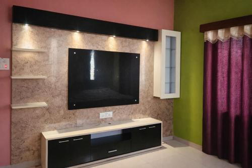 a flat screen tv on a wall in a room at Singh ManSion in Purnea