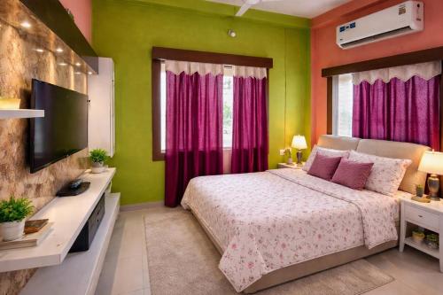 a bedroom with a bed with pink and green walls at Singh ManSion in Purnea
