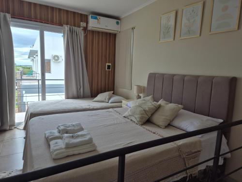 a bedroom with two beds with towels on them at ByF apart duplex excepcional en complejo Amaiur DPTO N5 Av Alem Norte in Federación