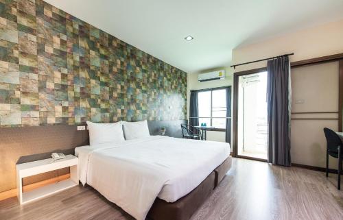 a hotel room with a large bed and a window at Prajaktra City Hostel in Udon Thani