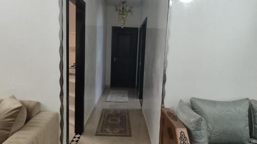 a living room with a couch and a black door at maison achab in Asilah