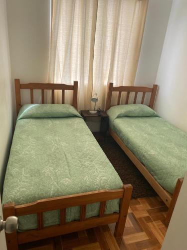 two beds sitting next to each other in a room at Alojamiento Parque Libertad in La Serena