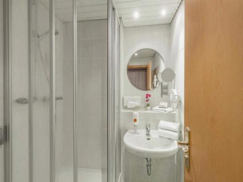 a white bathroom with a shower and a sink at Kaiserhof Feldberg- Standard Double Room in Feldberg
