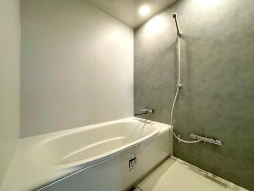 a white bath tub in a bathroom with a shower at mahoratto inn in Aomori