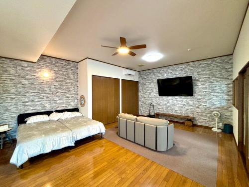 a bedroom with a bed and a tv on a brick wall at mahoratto inn in Aomori