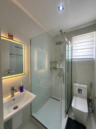 a bathroom with a shower and a toilet and a sink at Luxury 2 Bedroom Apartment with 2 Private Patios in Lekki Phase 1 in Lekki