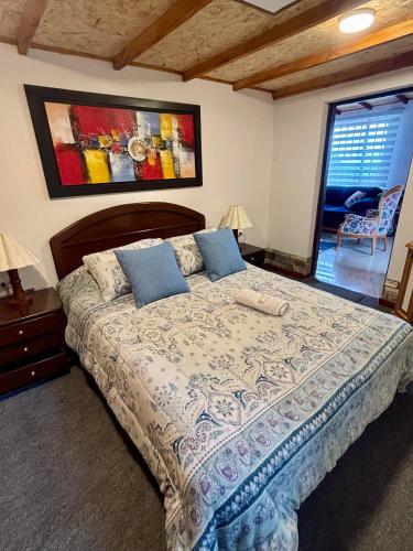 a bedroom with a large bed with blue pillows at Casa campestre Hotel Cerro Fuerte in Sopo