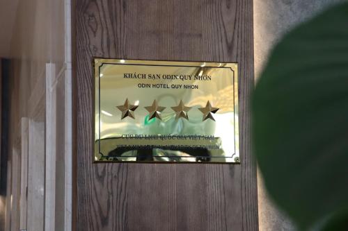 a glass door with three stars in a window at Odin Hotel Quy Nhon in Quy Nhon