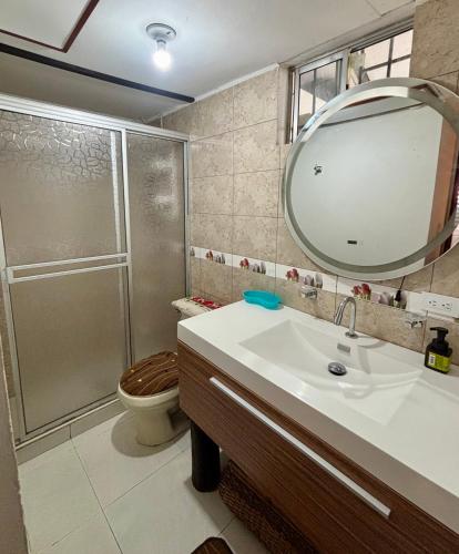 a bathroom with a toilet and a sink and a mirror at Casa campestre Hotel Cerro Fuerte in Sopo