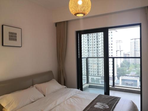 a bedroom with a bed and a large window at Miri apartment in Kunming