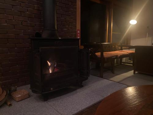 a fireplace in a room with a brick wall at Guest House Eleven Village Fukiya in Fukiya