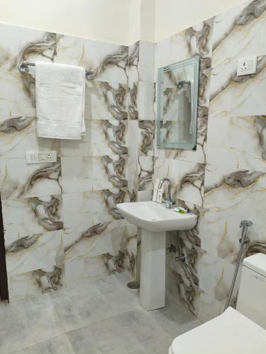 a bathroom with a sink and a marble wall at BODHI Residency in Greater Noida