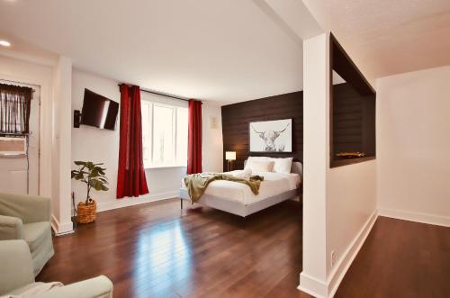 a bedroom with a bed and red curtains at Laurier Suites in Gatineau