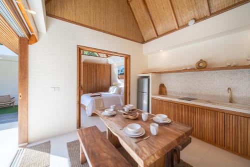 a kitchen and living room with a table and a bed at Tropicool Hideaway Villas in Nusa Lembongan