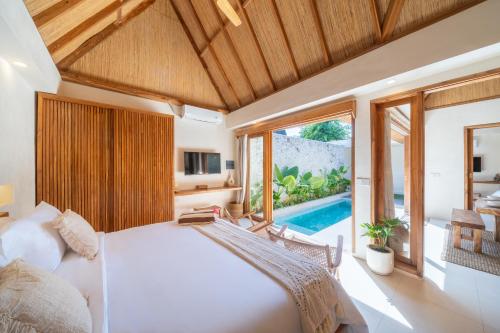 a bedroom with a large bed and a pool at Tropicool Hideaway Villas in Nusa Lembongan