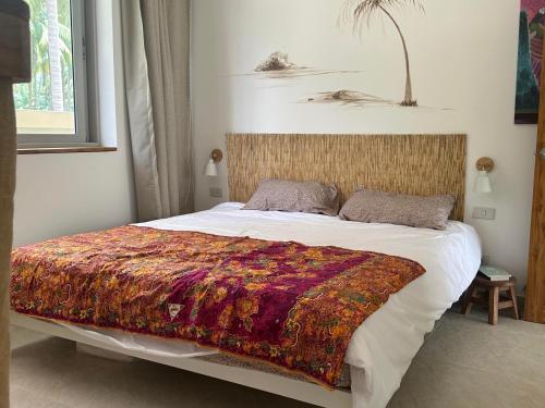 a bedroom with a bed with a colorful blanket on it at Villa Colette in Ban Hua Laem Ma So