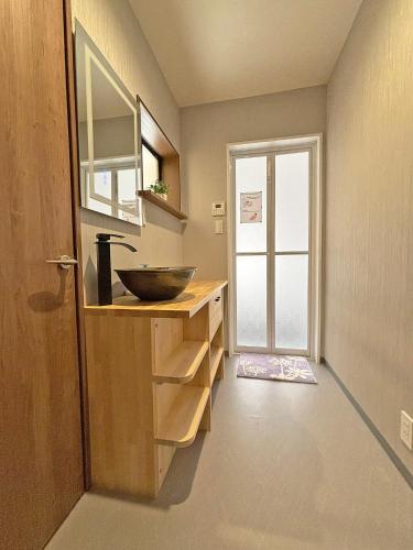 a bathroom with a bowl sink and a door at 東寺の宿夏 in Kyoto