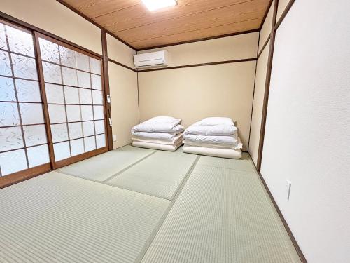 an empty room with two beds and a window at 東寺の宿夏 in Kyoto