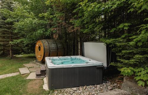a hot tub and a barrel in a yard at Fiddler Lake Resort - Deer 41 in Mille-Isles