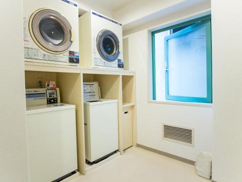 a laundry room with a washer and dryer and a window at Hotel Belleview Nagasaki Dejima in Nagasaki