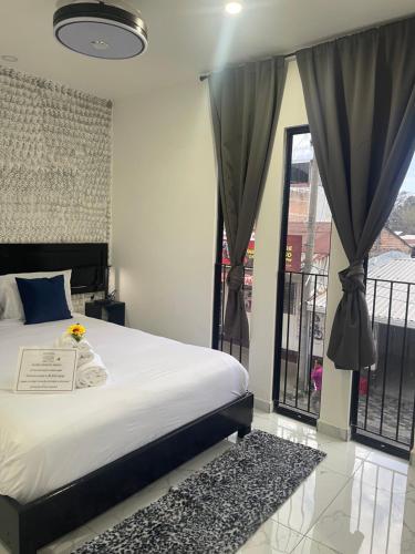 a bedroom with a bed and a window with curtains at The Bello Lodging B in Sonsonate