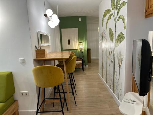 a dining room with a table and yellow chairs at Aparthotel Boutique Poniente Playa in San Antonio