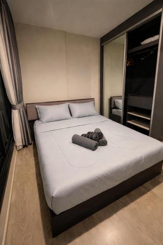 a bed with two pairs of shoes on it at The Base Central Pattaya in Pattaya