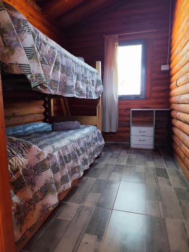 a bedroom with two bunk beds in a log cabin at Cabañas Paraje de los Sueños in Uspallata