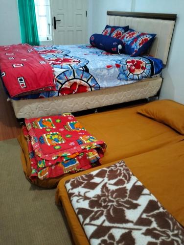 two beds sitting next to each other in a room at KHAIRI HOMESTAY in Bukittinggi