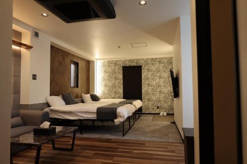 a bedroom with two beds and a couch at 広島の宿ことときー蓮ー別館 in Hiroshima