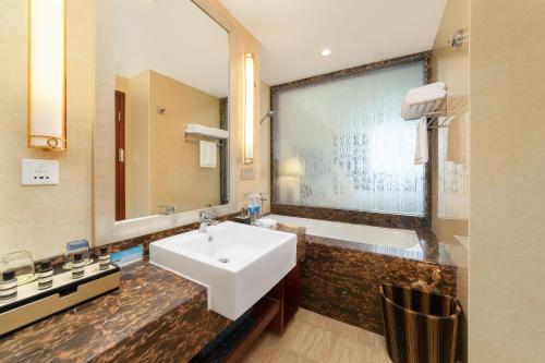 a bathroom with a white sink and a bath tub at 都江堰国堰宾馆 in Dujiangyan
