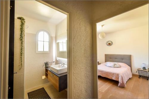 a bathroom with a bed and a sink in a room at appartement dans villa aquarelle in Biguglia