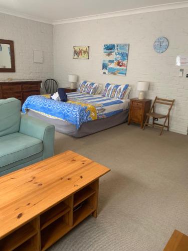 a bedroom with a bed and a couch and a table at Bentworth Lodge in Carramar