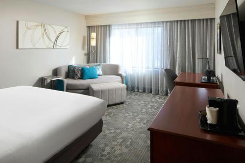 a hotel room with a bed and a couch at Courtyard Newark Granville in Newark