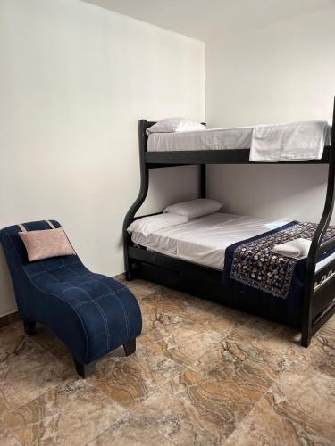 a bedroom with two bunk beds and a chair at no está activo in Salinas
