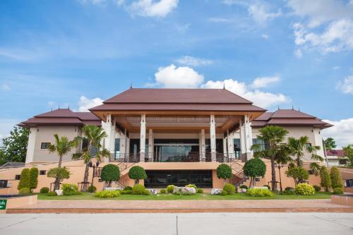 un gran edificio con balcón y palmeras en Royal Nakhara Hotel and Convention Centre en Nong Khai