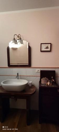 ein Badezimmer mit Waschbecken und einem Bild an der Wand in der Unterkunft AnimAntica in Lido di Pomposa