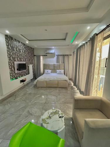 a large bedroom with two beds and a couch at City Xcape Niche in Lekki