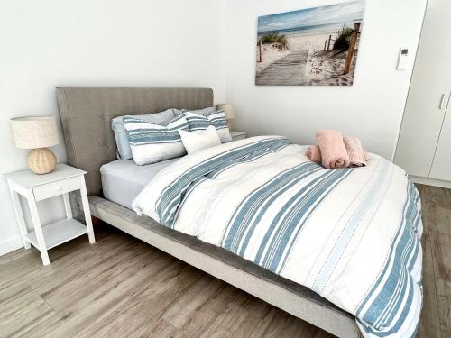 a bedroom with a bed with a beach picture on the wall at Private Barwon Heads Cottage Walk to River in Barwon Heads